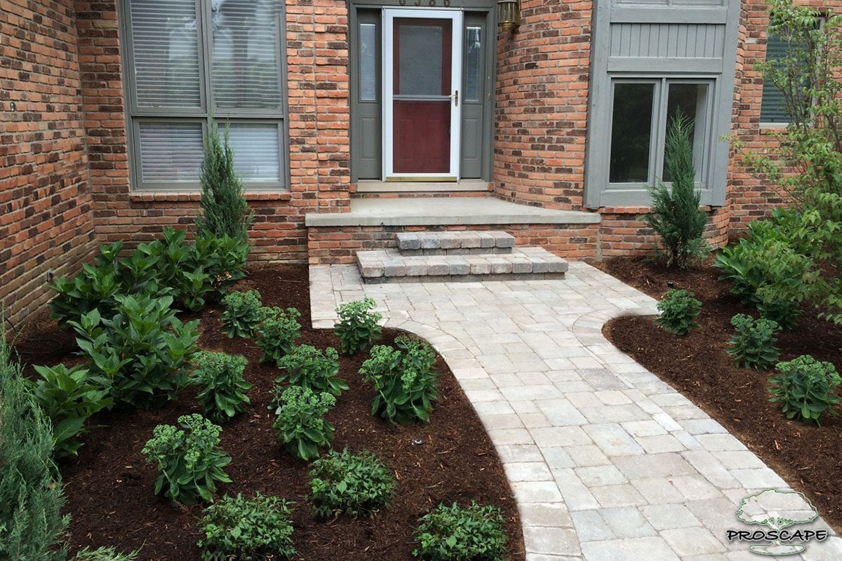 Brick house with landscaped front yard pathway.