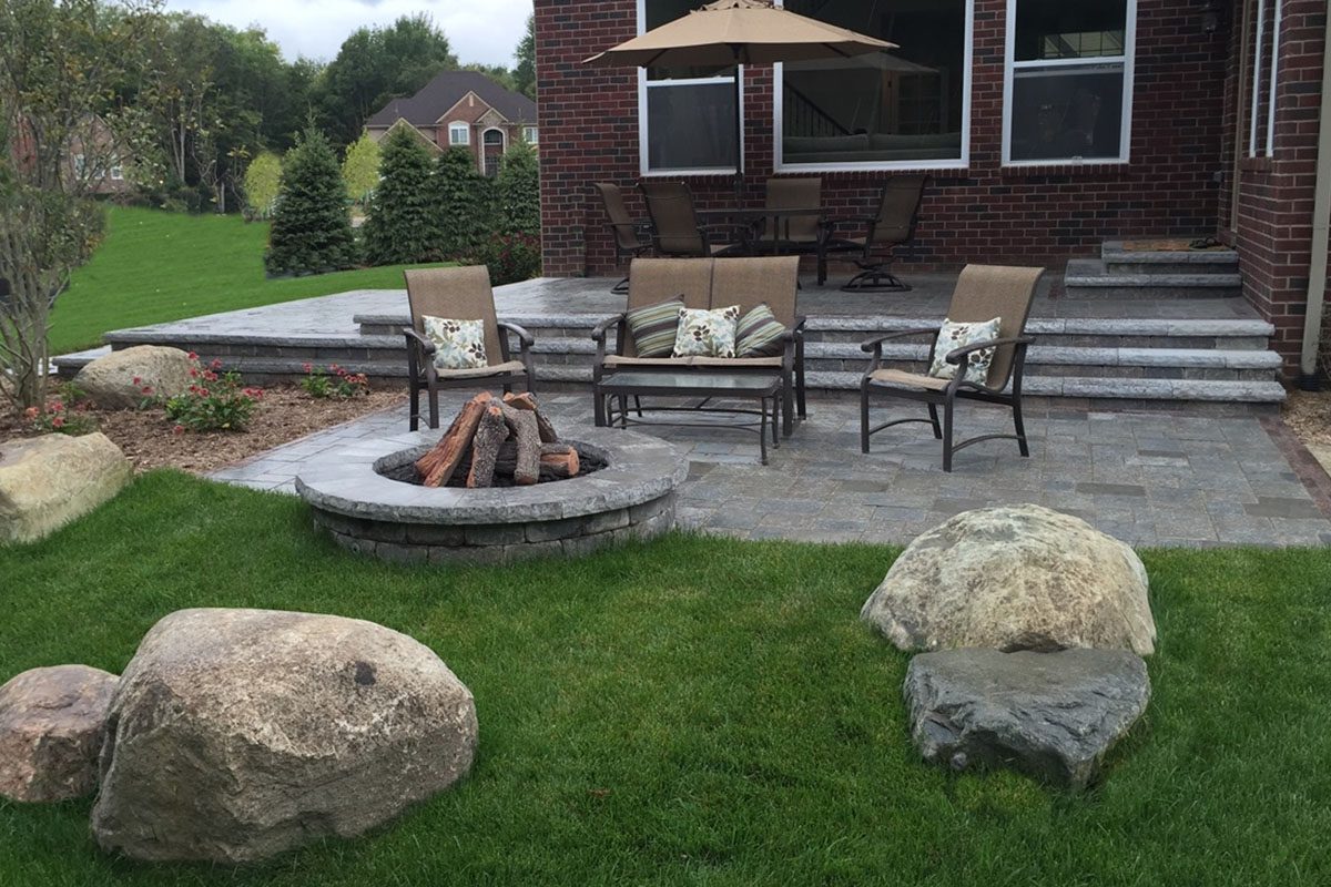 Patio with chairs and stone fire pit.