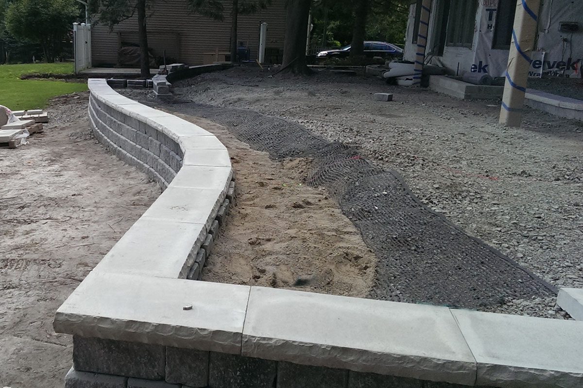Curved stone retaining wall under construction.