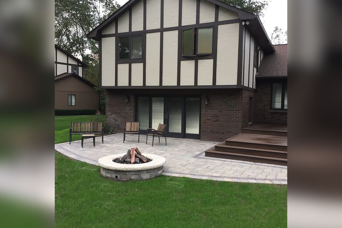 Two-story house with patio and fire pit.