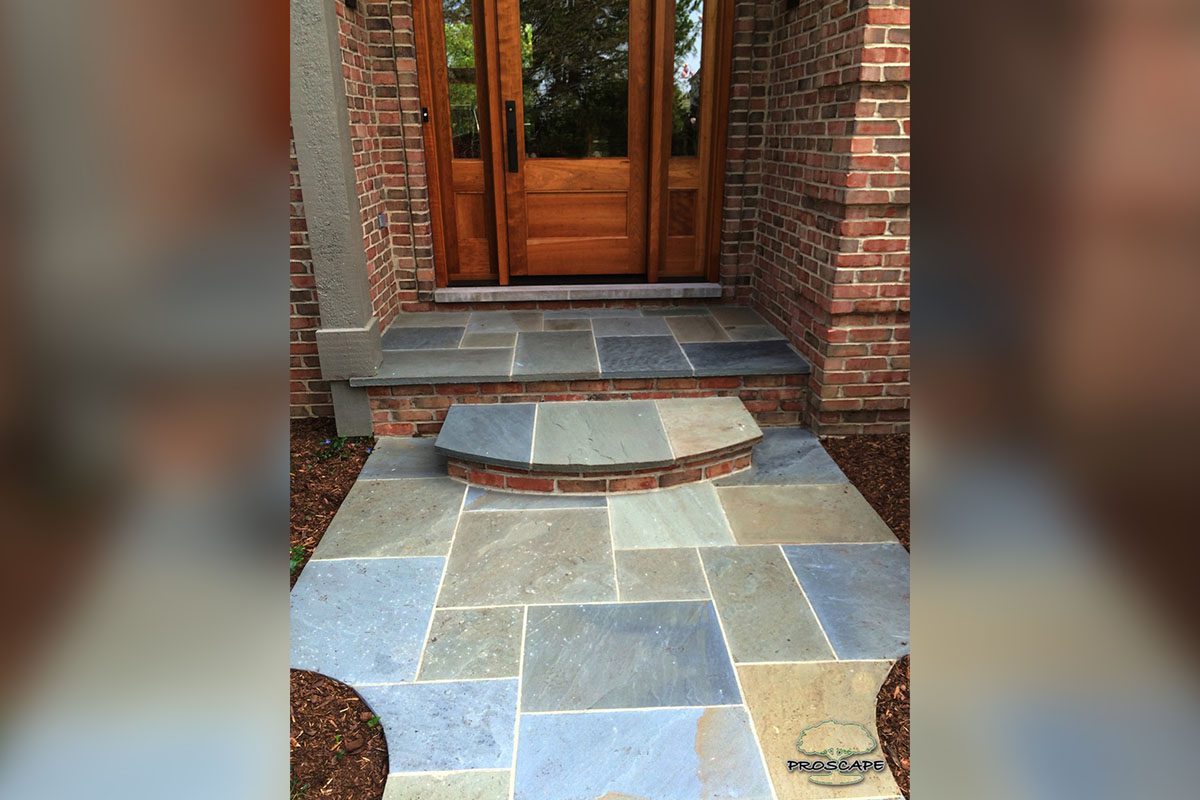 Stone-tiled entrance with wooden door.