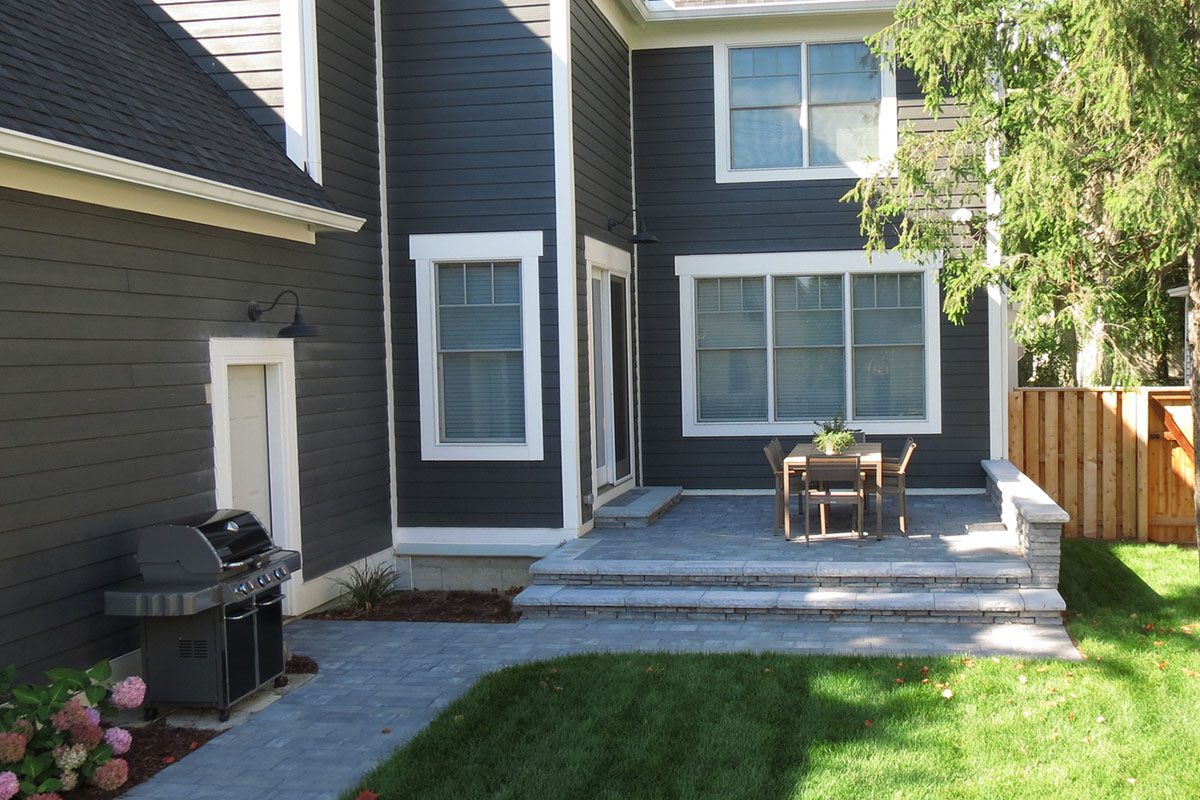 Backyard patio with grill and dining set.