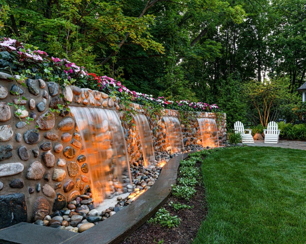 Garden with stone waterfalls and lush greenery.