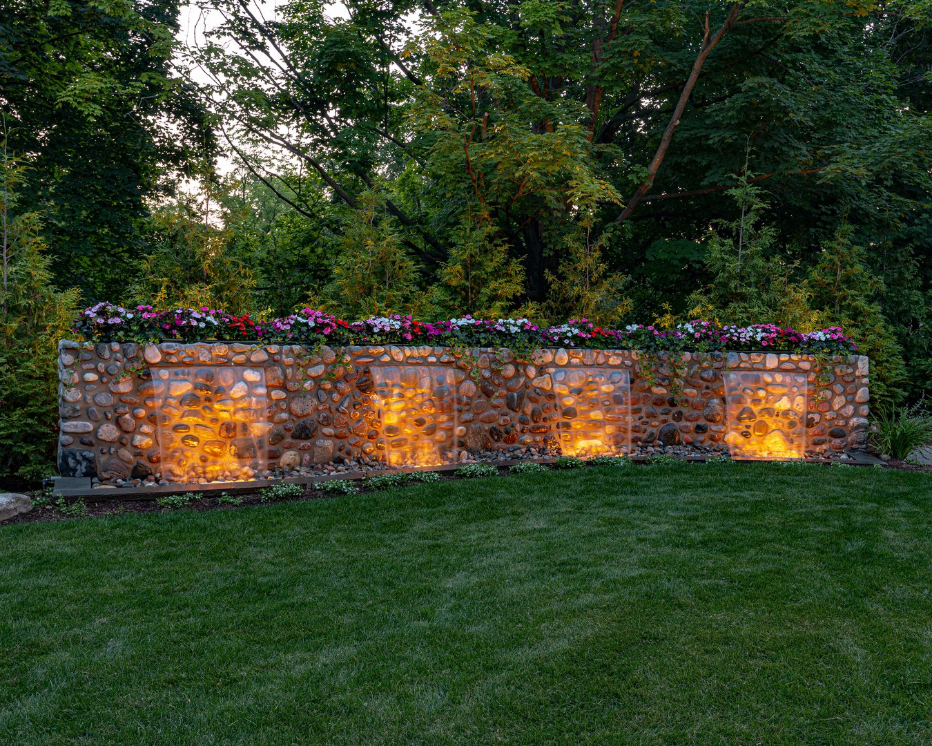 green-2 Illuminated stone wall with colorful flowers.