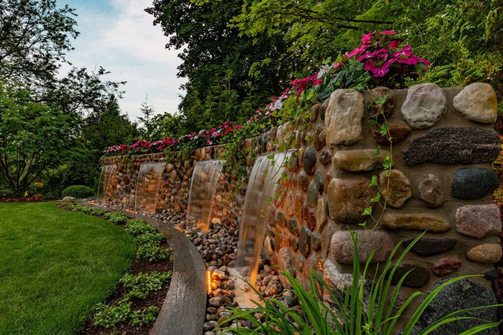 Garden waterfall feature with colorful flowers.