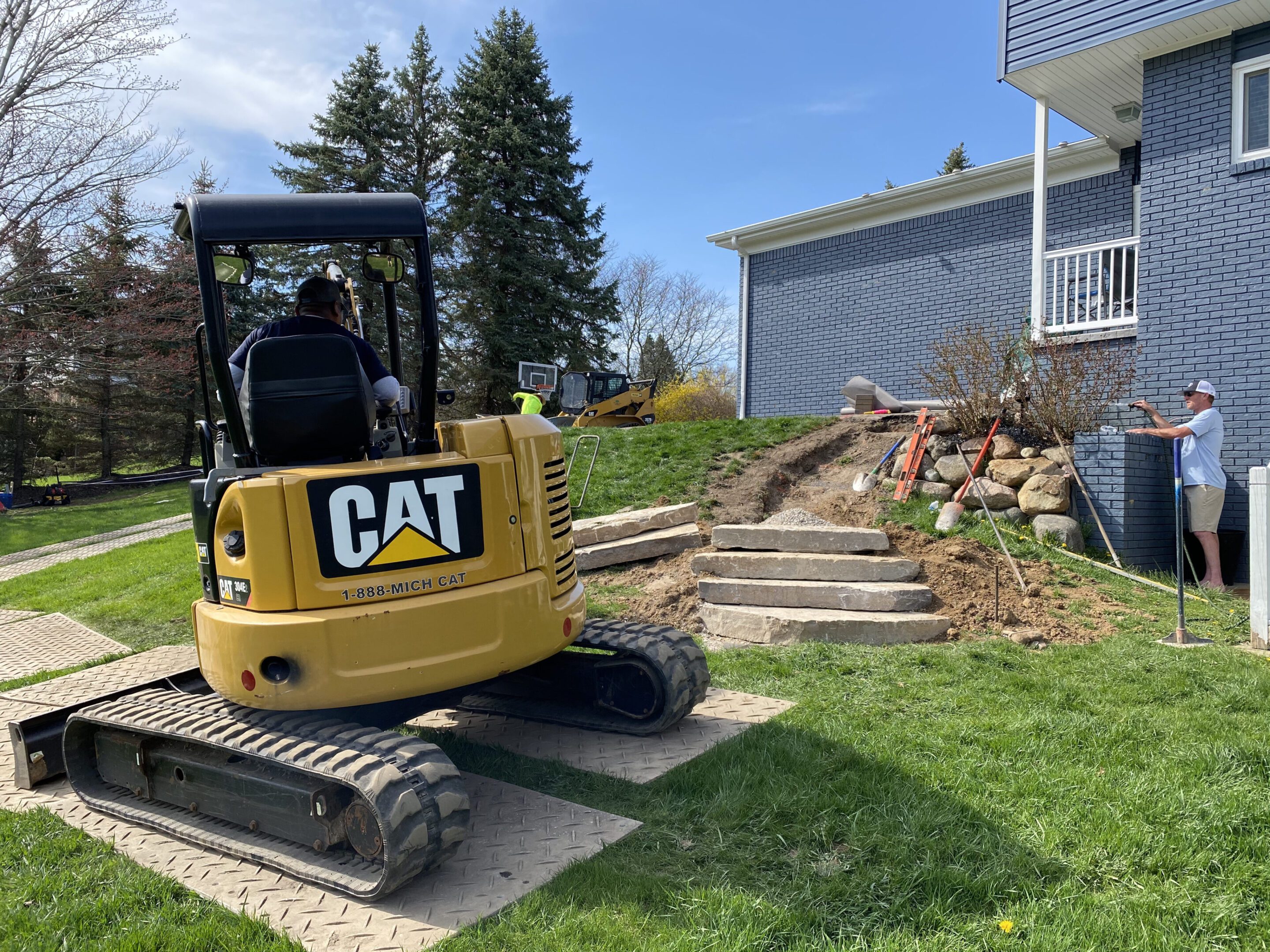 A yellow cat tractor parked in the grass.