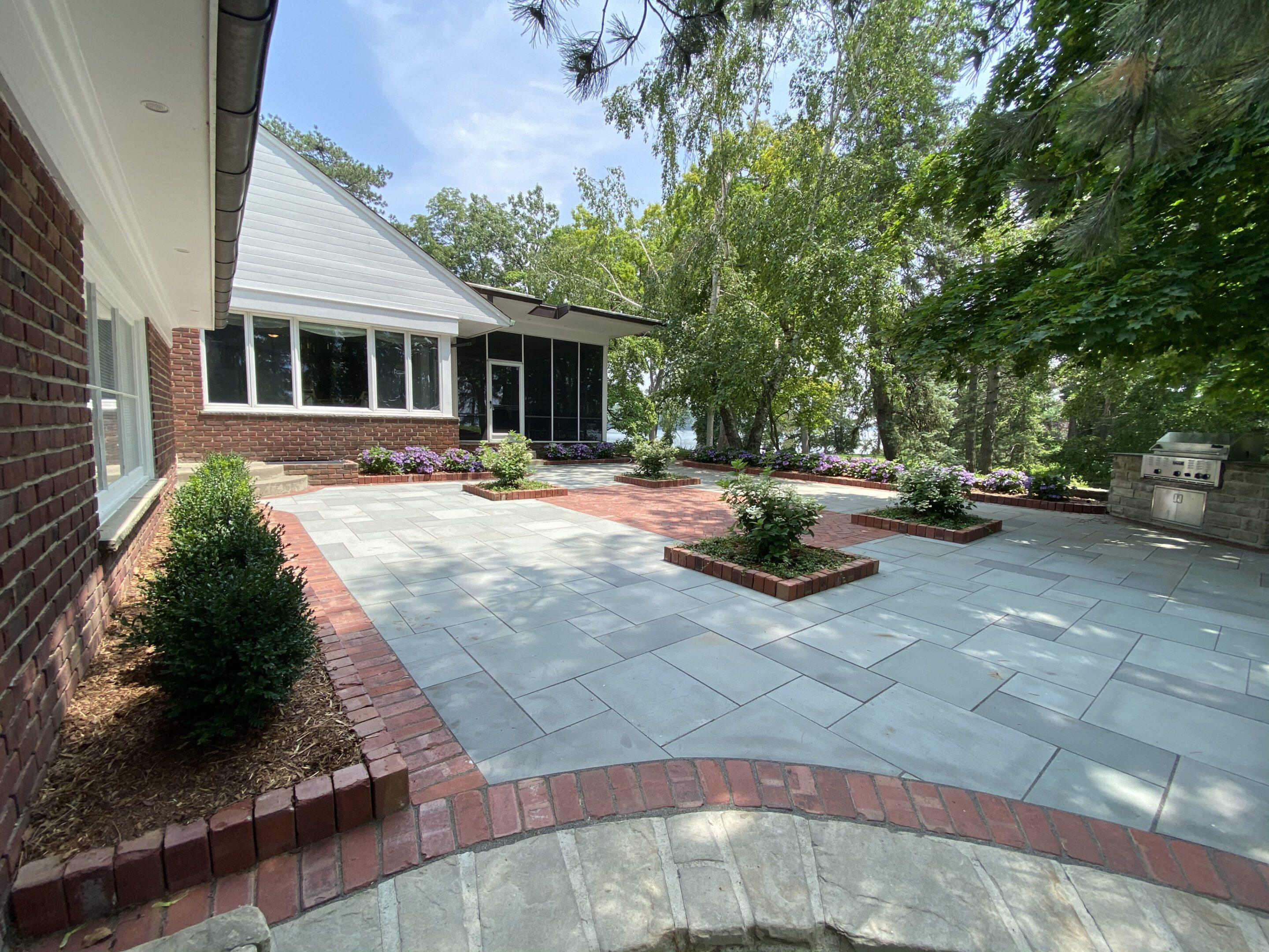 A large patio with brick and stone flooring.