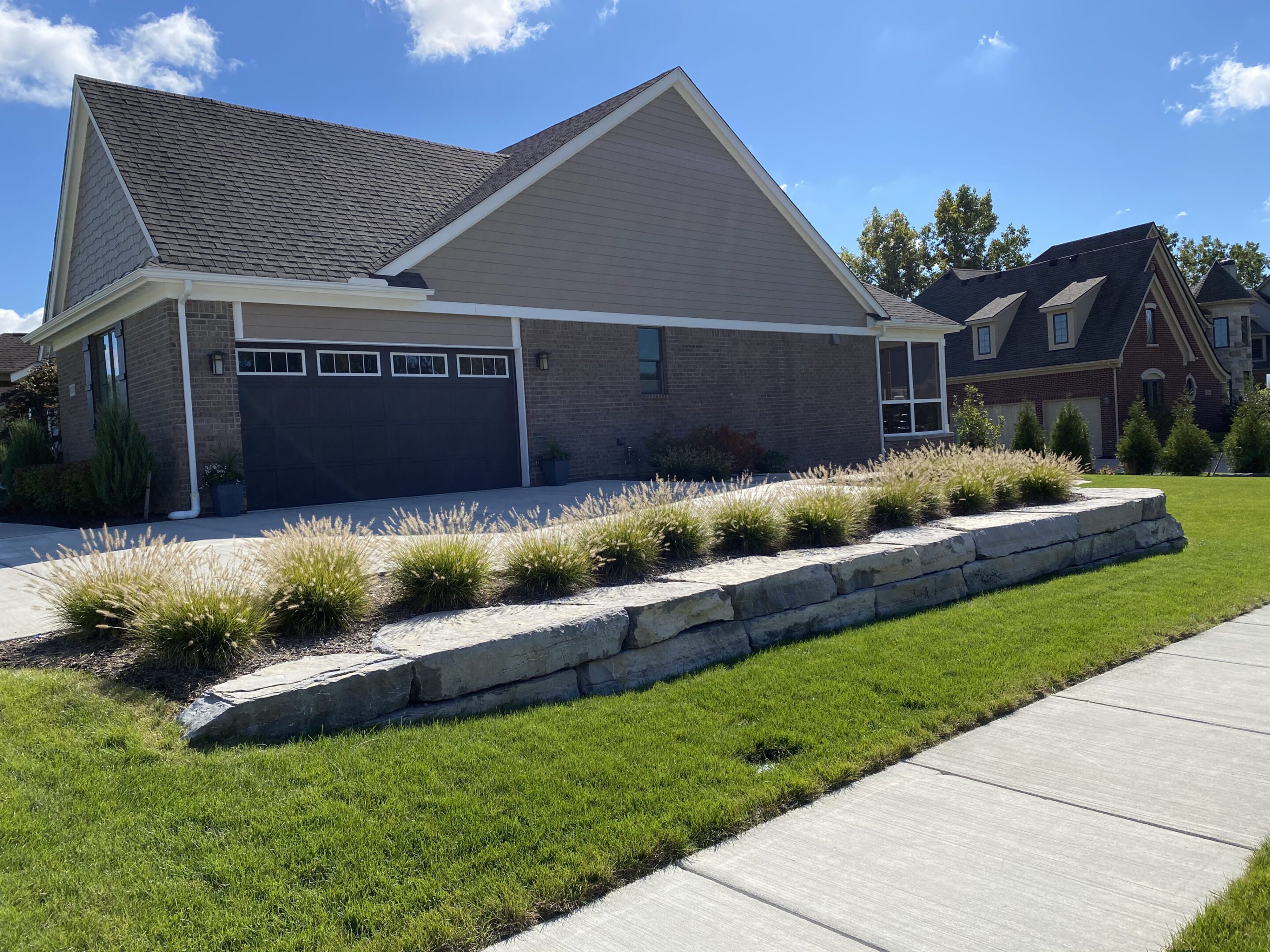 A house with a driveway and landscaping in the front yard.
